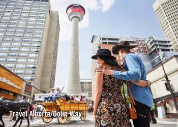 Couple regardant le défilé des Premières Nations sur l'avenue Stephen avec la tour de Calgary en arrière-plan